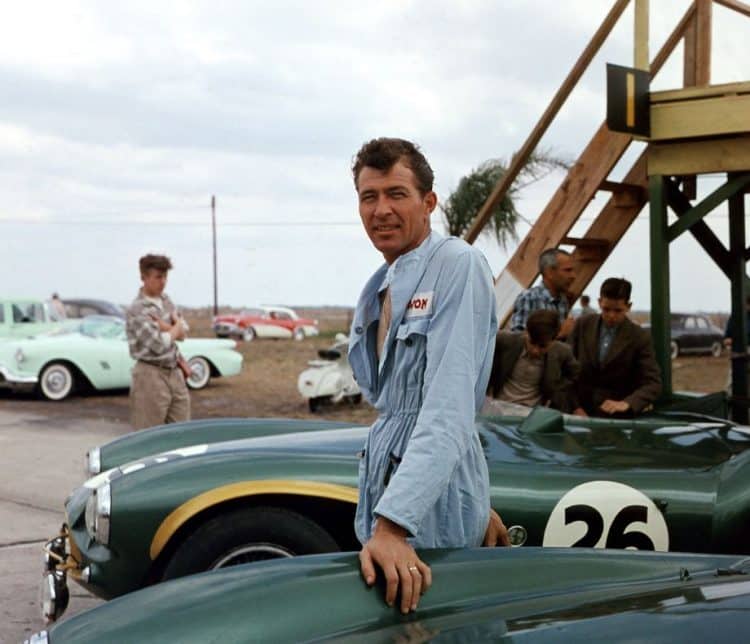 Caroll Shelby posando sobre seu carro da Aston Martin
